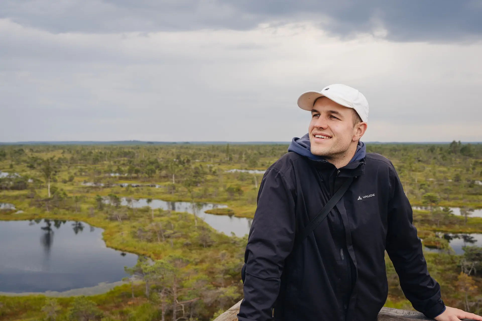 Profile photo showing the author of the blog in a black jacket in front of a green background with lakes.
