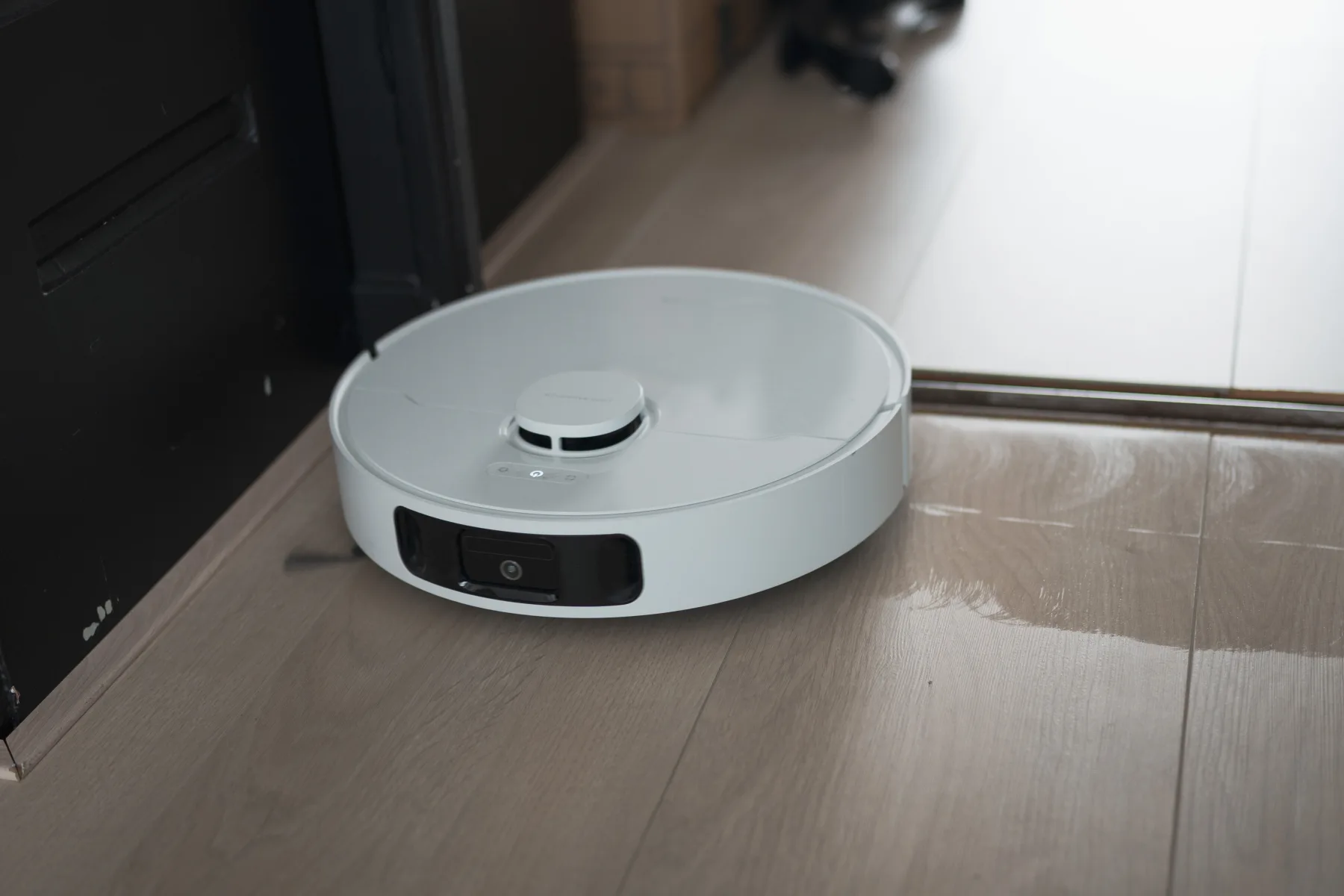 Robot vacuum on a PVC floor vacuuming and mopping.